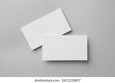 Blank business cards on light grey background, flat lay. Mockup for design