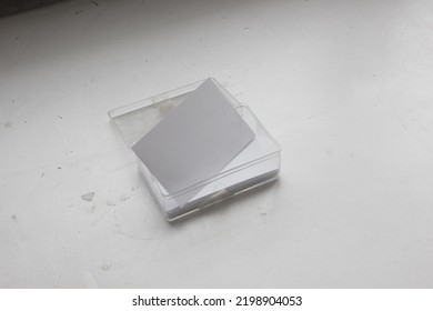 The Blank Business Name Card And The Stack Ones In The Old Transparent Box Is Isolated On Dirty Texture Background, For Brand Identity Mockup Or Showcase Presentation.