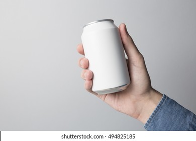 Blank Can In Hand On White Background, Ready To Replace Your Design.