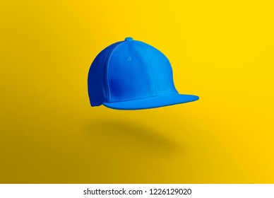 Blank cap in perspective view. Blue snapback on yellow background. Blank baseball snap back cap for your design. Mock up hat cap for you logo, brand identity etc.