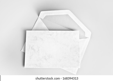 Blank Card And Envelope Over Grey Background