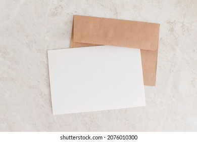 Blank Card Mock Up. Layout Of Sheet Of Paper On Craft Envelope And Marble Texture. Horizontal Canvas Template With Copy Space For Invitations, Greeting, Wedding Cards. Natural Beige Colors.