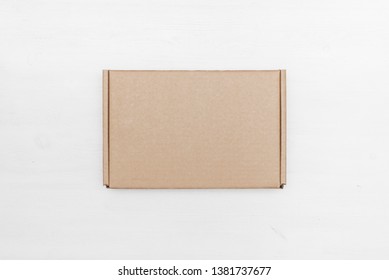 Blank cardboard parcel box on a white table background.
