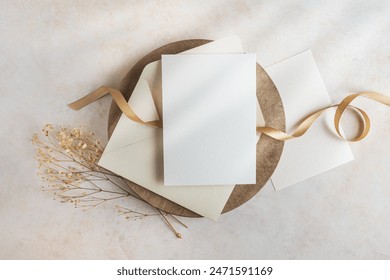 Blank cards 5x7 and envelope mockup with gold ribbon. dried flowers and sunbeam; bohemian wedding invitation sample for designers