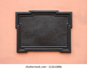 Blank cast-iron plaque on stone wall. Add your own text or image. Clipping path is included