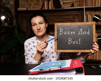 Blank Chalkboard In A Hand With Phrase Boom And Bust . Horizontal Shot.
