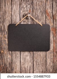 Blank Chalkboard Sign Hanging From Old Wooden Background.