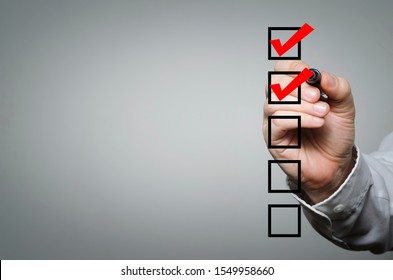 Blank Checklist On The Whiteboard With Businessman Hand Drawing A Red Check Mark In The Check Box