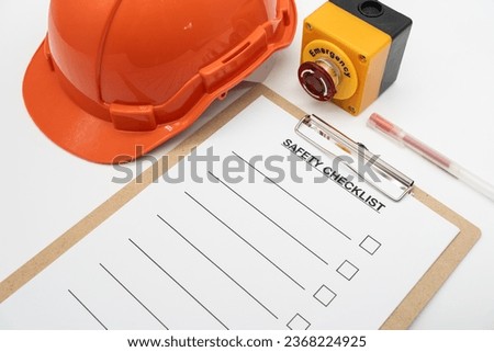 Blank checklist paper during safety audit and risk verification. safety checklist form with Hard hat or Safety hat and Emergency Stop Button.