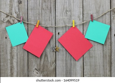 Blank Christmas Note Cards Hanging From Clothesline By Antique Rustic Wood Background; Christmas Background With Red And Green Copy Space