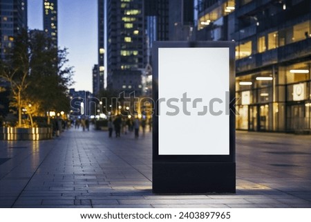 Blank city format Billboard (LightPoster, CityLight) banner pylon in in the city center mock-up at night. Blurred background, copy space