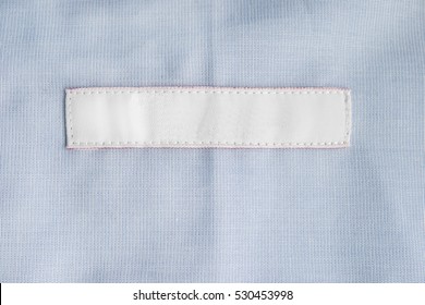 Blank Clothes Label On Blue Cloth As A Background