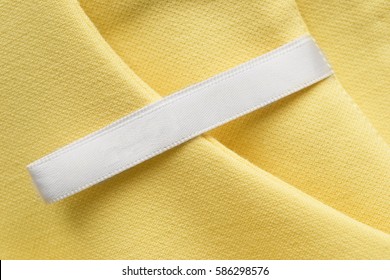 Blank Clothes Label On Yellow Cotton As A Background