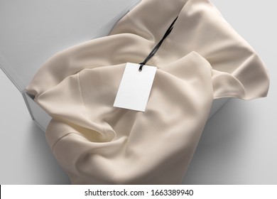 Blank Clothing Box, Package With Elegant Silk Fabric And Blank Tag Label Mockup To Place Your Design, On A White Background. Isometric View Fashion Branding Scene