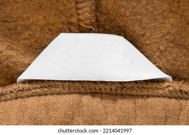 Blank Clothing Label Closeup On Brown Fabric Background