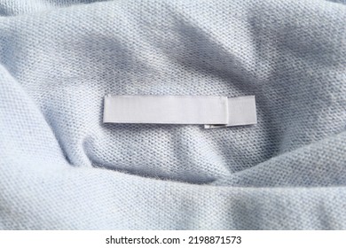 Blank clothing label on stylish cashmere apparel, closeup