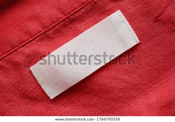 Blank clothing tag label on linen shirt fabric\
texture background