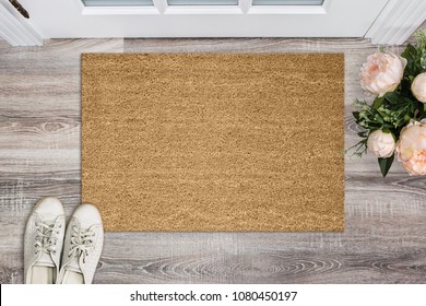 Blank coir doormat before the door in the hall. Mat on wooden floor, flowers and shoes. Welcome home, product Mockup