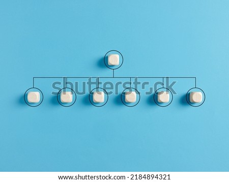 Blank company hierarchical organizational chart of wooden cubes on blue background. Human resources management and business concept