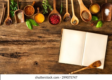 Blank cookbook and spices on wooden table