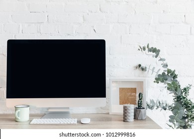 Blank Copmuter Screen On Workplace In Front On White Brick Wall, Mockup Concept