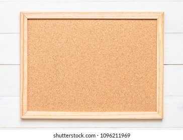 Blank cork board with corkboard texture background with wooden frame hanging on white wood wall for bullentin, memo or noticeboard announcement