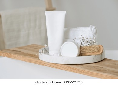 Blank Cosmetic Packaging Mockup. Copy Space Tube With Shampoo Or Hair Treatment, Jar Of Face Cream And Towels Stand Close To Nail Brush In Bathroom, Against White Background