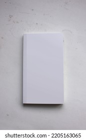 A Blank Cover Page Of A Vertical Closed Pocket Book Is Isolated On Minimal Dark Grey Background, For Catalog Presentation, Mystery Novel, Study Book, And Minimalism Literature Book Mockup. 