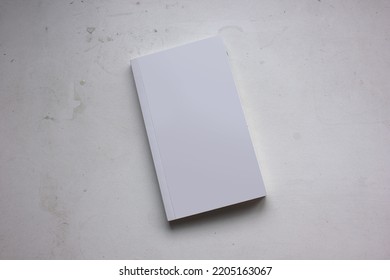 A Blank Cover Page Of A Vertical Closed Pocket Book Is Isolated On Minimal Dark Grey Background, For Catalog Presentation, Mystery Novel, Study Book, And Minimalism Literature Book Mockup. 