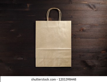 Blank Craft Paper Bag On Wooden Background. Responsive Design Mockup. Flat Lay.