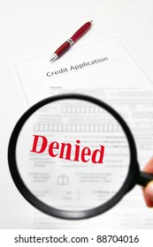 A Blank Credit Application And Magnifying Glass With Denied Text