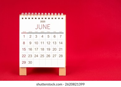 Blank desk calendar for June 2025 on red color background.