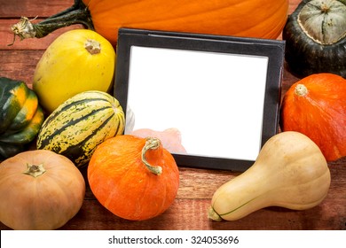 blank digital tablet surrounded by pumpkin and winter squash, Halloween or Thanksgiving decoration - Powered by Shutterstock