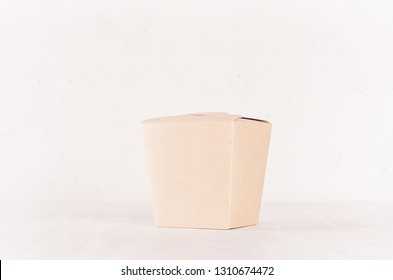 Blank disposable brown paper box for takeaway food on white wood shelf closeup, mockup food packaging for cafe, bar and restaurant.