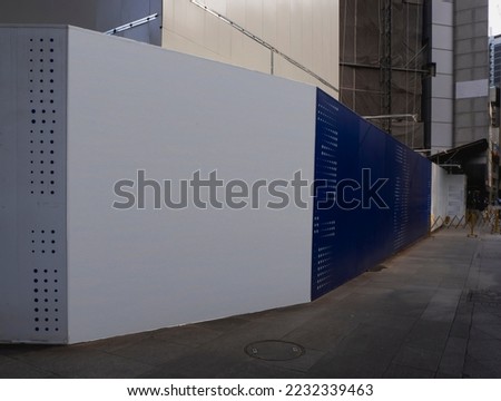Blank empty construction hoarding space for advertisement mockup. Construction site area in the central business district.