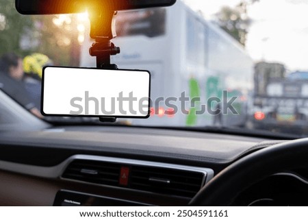 Blank empty screen. Copy space. Empty space for text. Mock up smart phone in car, clipping path. Smartphone in a car use for Navigate or GPS. Mobile phone with isolated white screen. 