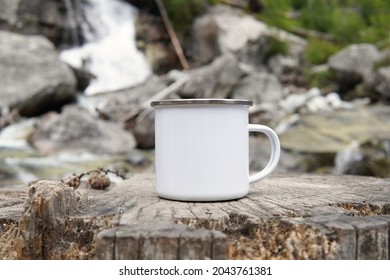 Blank enamel coffee mug, white camping cup mockup in wild nature. - Shutterstock ID 2043761381