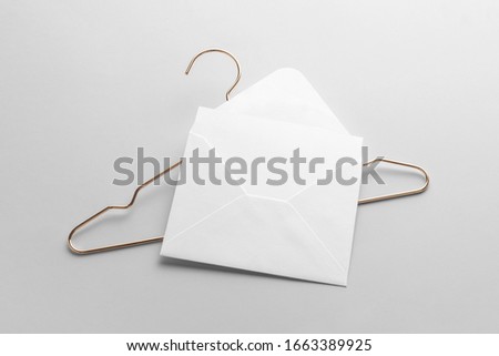 Blank envelope and card mockup template to place your design. With hanger accessory on white background. Fashion branding stationery scene
