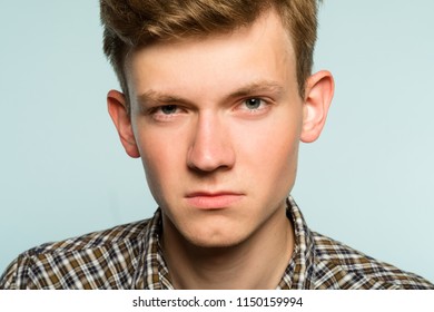 blank expression. serious confident man with poker face. portrait of a young guy on light background. emotion facial expression. feelings and people reaction.