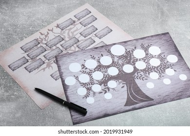 Blank family tree charts and pen on grey table - Shutterstock ID 2019931949