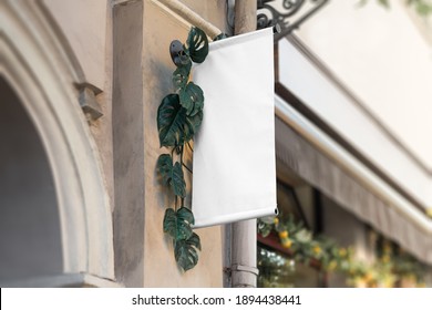 Blank Flag Sign Mockup In The Urban Environment, On The Facade, Empty Space To Display Your Store Sign Or Logo