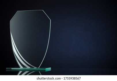 Blank Glass Trophy Or Award Plaque Ready To Be Engraved With The Name Of The Winner Of A Competition Or Championship Over A Dark Background With Copy Space