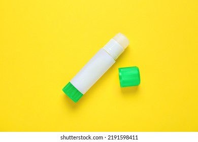 Blank glue stick on yellow background, top view