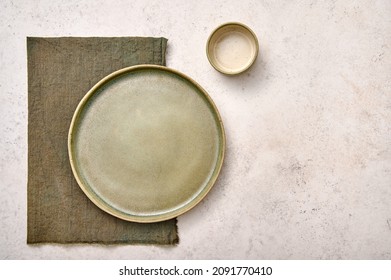Blank green plate with napkin and saucepan on white textured background. Design concept, copy space - Shutterstock ID 2091770410
