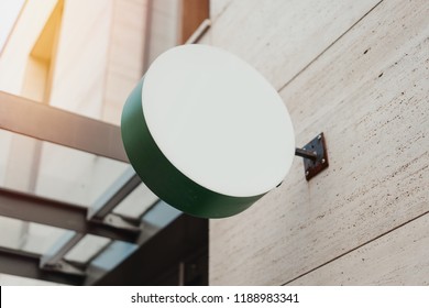 Blank green round store signboard Mockup. Empty circular illuminated shop lightbox template mounted on the wall. Street sign, signage - Powered by Shutterstock