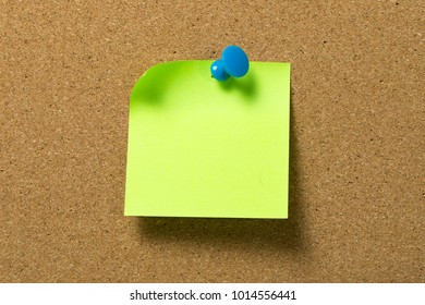 Blank Green Sticky Note Pad Pinned To Corkboard Using A Blue Thumb Tack Pin