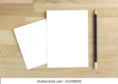 Blank Greeting Card Mockup With Pencil On Wooden Table