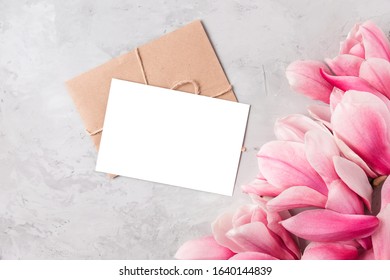 Blank greeting card with spring pink magnolia flowers on white background. Wedding invitation. Mock up. Flat lay. Top view with copy space - Shutterstock ID 1640144839