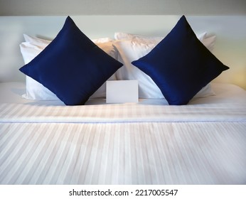 Blank Greetings Card At The Dark Blue Pillow On The Bed With Hotel Turn Down Service