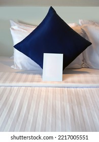 Blank Greetings Card At The Dark Blue Pillow On The Bed With Hotel Turn Down Service